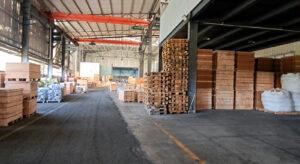 Warehouse aisle with wooden crates, pallets and overhead cranes