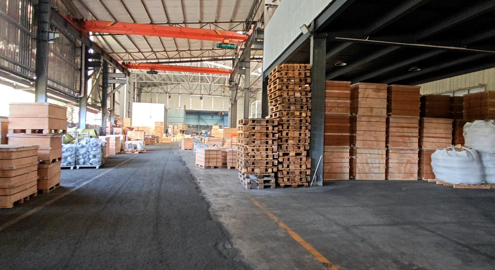 Warehouse aisle with wooden crates, pallets and overhead cranes