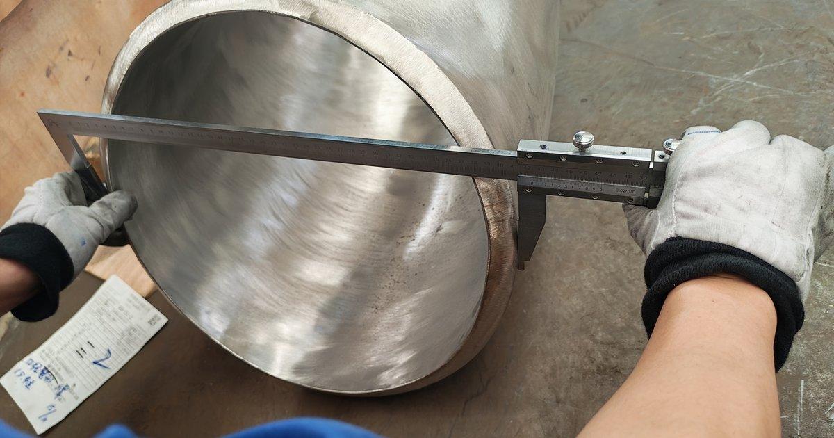 Caliper measuring the large end outside diameter of a stainless steel reducer at the HuaboPipe factory